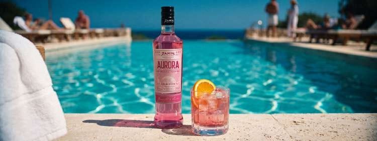 FlyOver Aurora by a swimming pool with a citrus drink