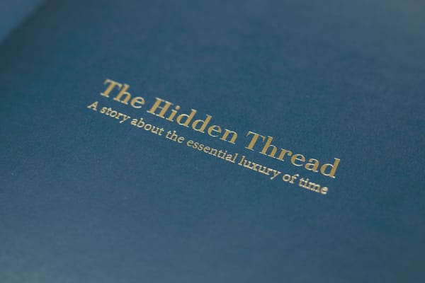 The title page of The Hidden Thread, gold foil lettering on deep blue paper